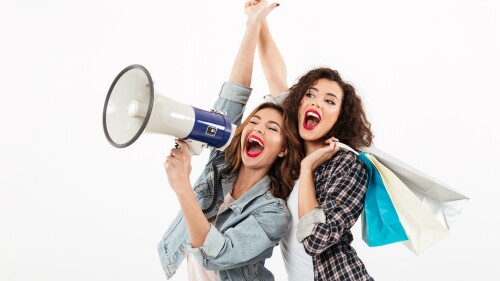 Two happy girls having fun together and looking away