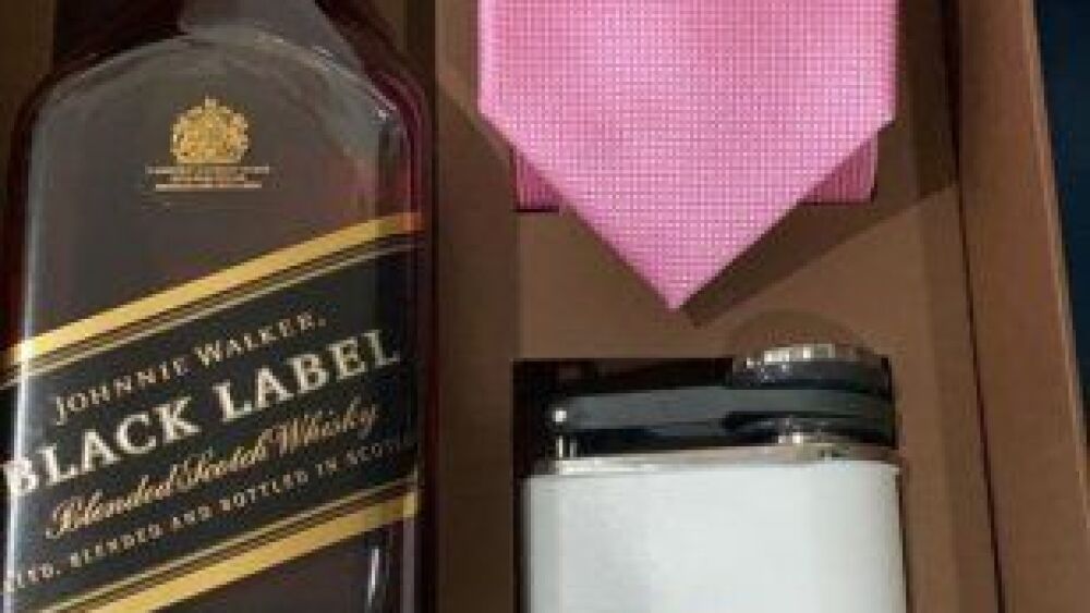 Los novios le entregaron un sourvenir a sus testigos, que consistía en una corbata, una botella de whisky y una licorera grabada.