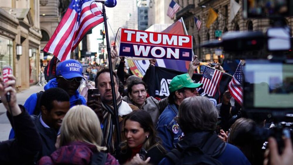 Los adherentes del expresidente estadounidense Donald Trump se paran cerca de la Torre Trump en Nueva York, EEUU, este lunes antes de que el ex mandatario realice su declaración prevista para este martes 4 de abril ante el Tribunal Penal de Nueva York, donde escuchará los cargos en su contra.