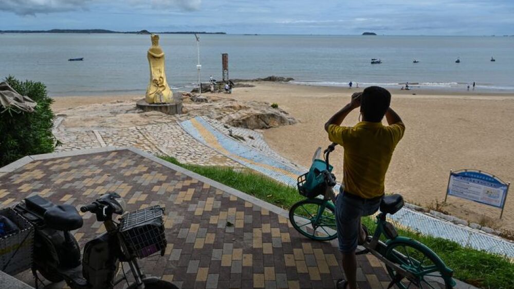 Un hombre mira a través de un par de binoculares en Xiamen, a través de las Islas Kinmen de Taiwán el 3 de agosto de 2022. La presidenta de la Cámara de Representantes de los Estados Unidos, Nancy Pelosi, aterrizó en Taiwán a última hora del 2 de agosto, desafiando una serie de advertencias y amenazas cada vez más severas de China que han generado tensiones entre las dos superpotencias del mundo en alza.